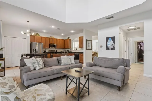 a living room with furniture a table and a chandelier