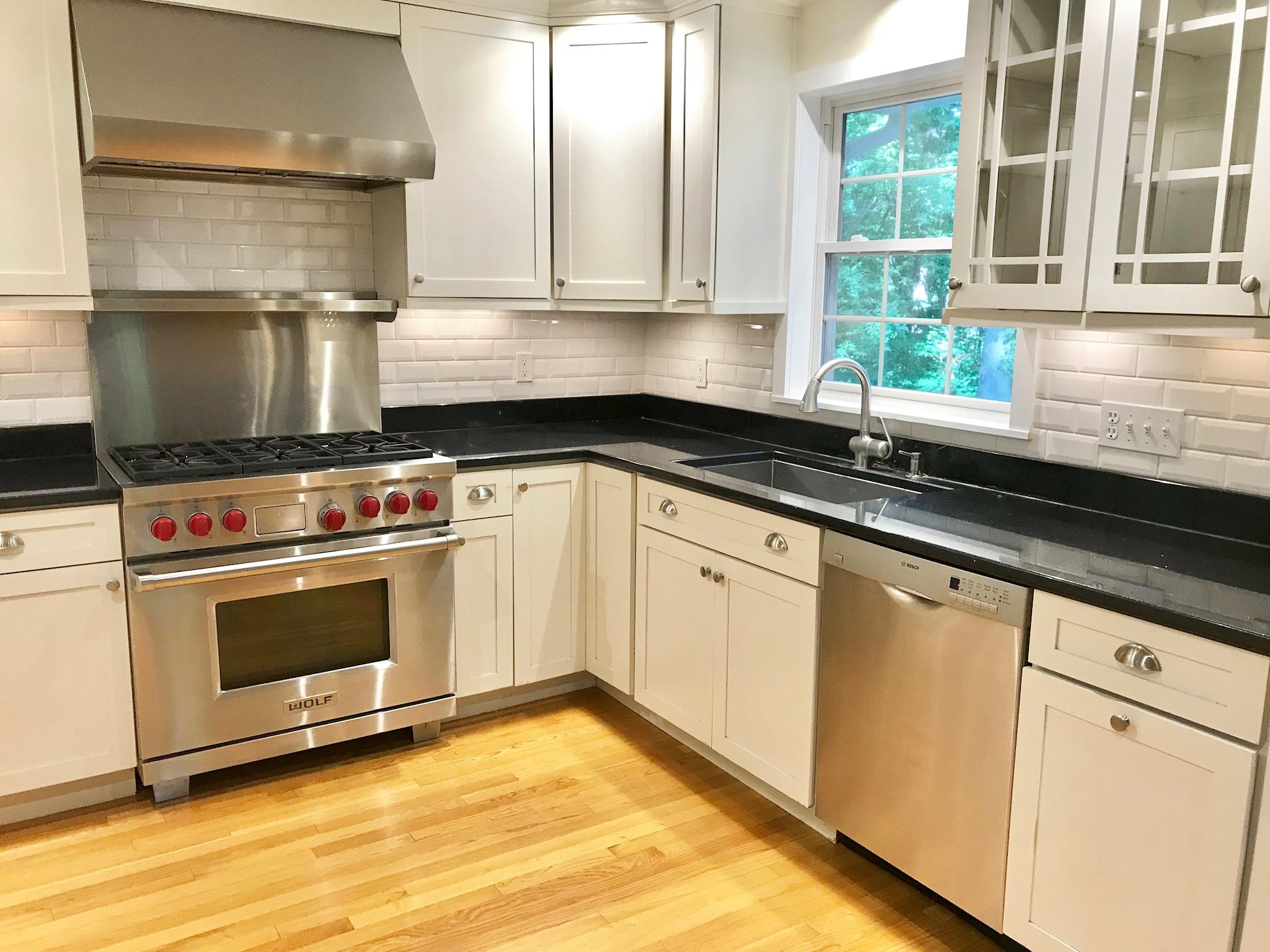 191 Laurel Road New Canaan, CT 06840 - Photo 13 of 39 a kitchen with granite countertop a stove sink and cabinets