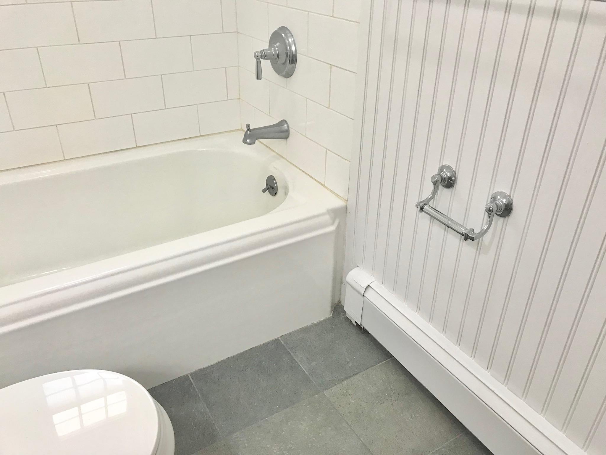 191 Laurel Road New Canaan, CT 06840 - Photo 26 of 39 a bathroom with a white tub and a shower curtain