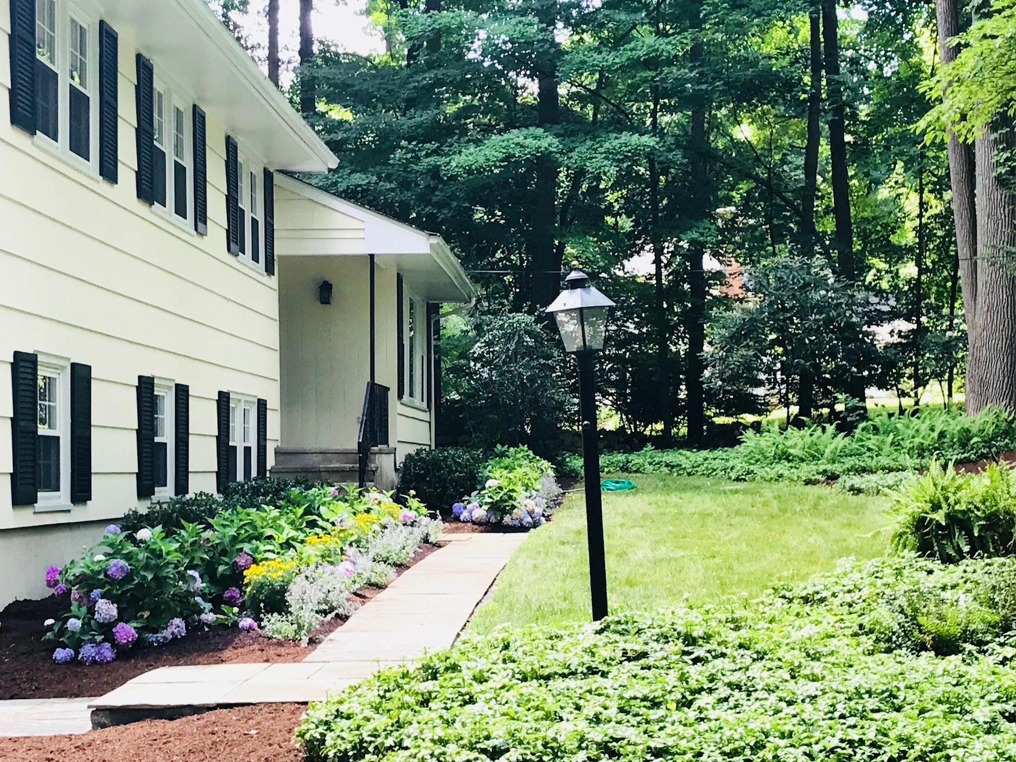 191 Laurel Road New Canaan, CT 06840 - Photo 3 of 39 a front view of a house with a yard