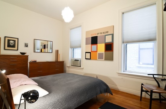 Undisclosed Address Chicago, IL 60647 - Photo 18 of 25 a bedroom with a bed and a dresser next to a window