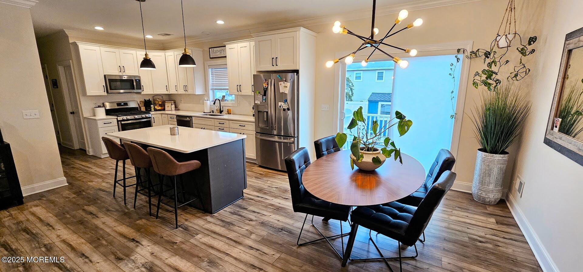 137 Jordan Road Brick, NJ 08724 - Photo 6 of 38 a kitchen with stainless steel appliances granite countertop a refrigerator a oven a sink a dining table and chairs with wooden floor