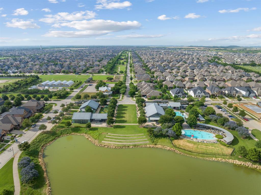 1821 Stonewall Road Argyle, TX 76226 - Photo 38 of 40 Expansive community showcasing a large pond, swimming pool with surrounding deck, multiple recreational buildings, and agricultural greenhouses