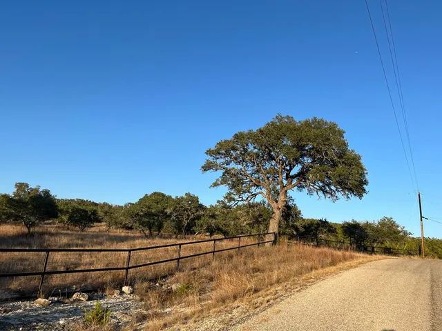 a view of a yard with wooden fence