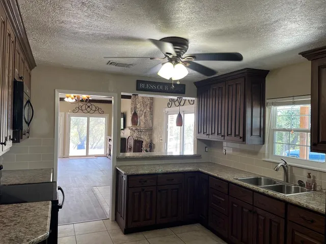 a kitchen with granite countertop a sink and a wooden cabinets
