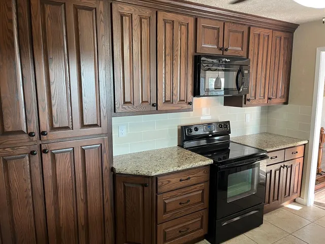 a spacious bedroom with a bed a dresser and wooden floor