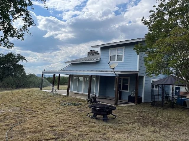 a backyard of a house with barbeque oven and table