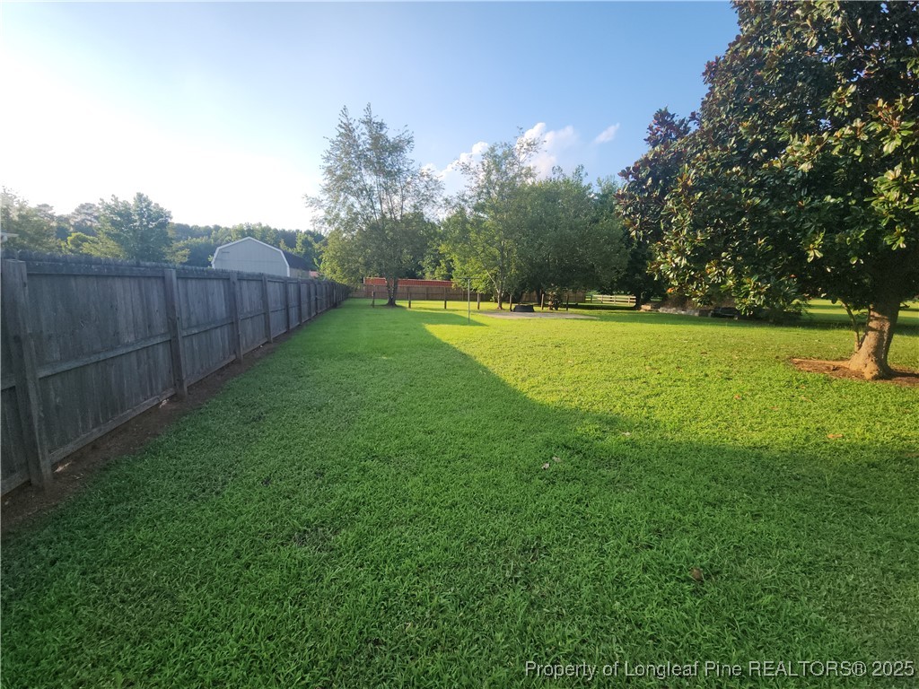 803 Antioch Church Road Dunn, NC 28334 - Photo 14 of 17 a view of a backyard with large trees and wooden fence