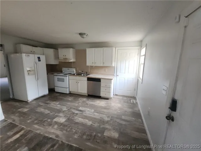 a view of a kitchen with refrigerator and a sink