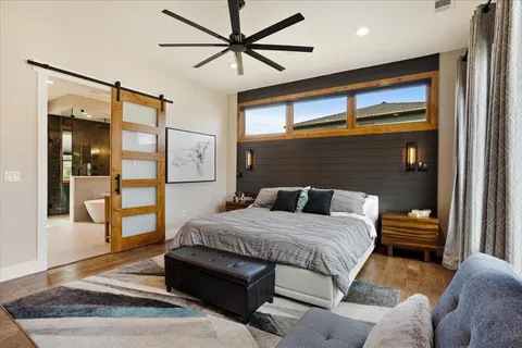 a bedroom with a large bed and a chandelier