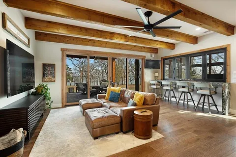 a living room with furniture a flat screen tv and a floor to ceiling window
