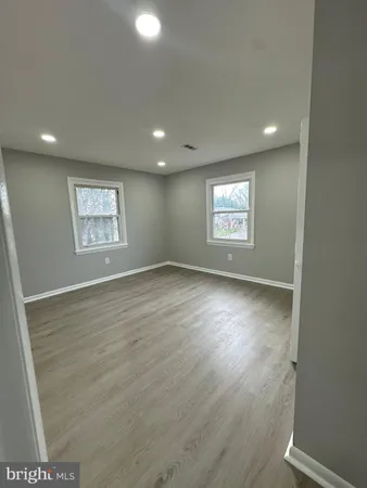 an empty room with wooden floor and window