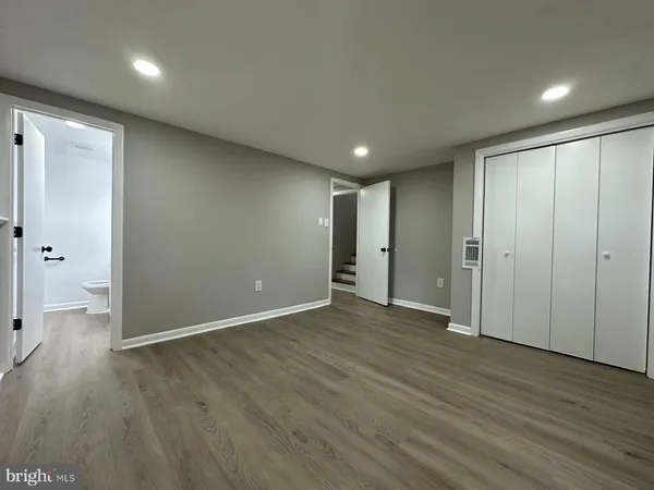 an empty room with wooden floor and entrance
