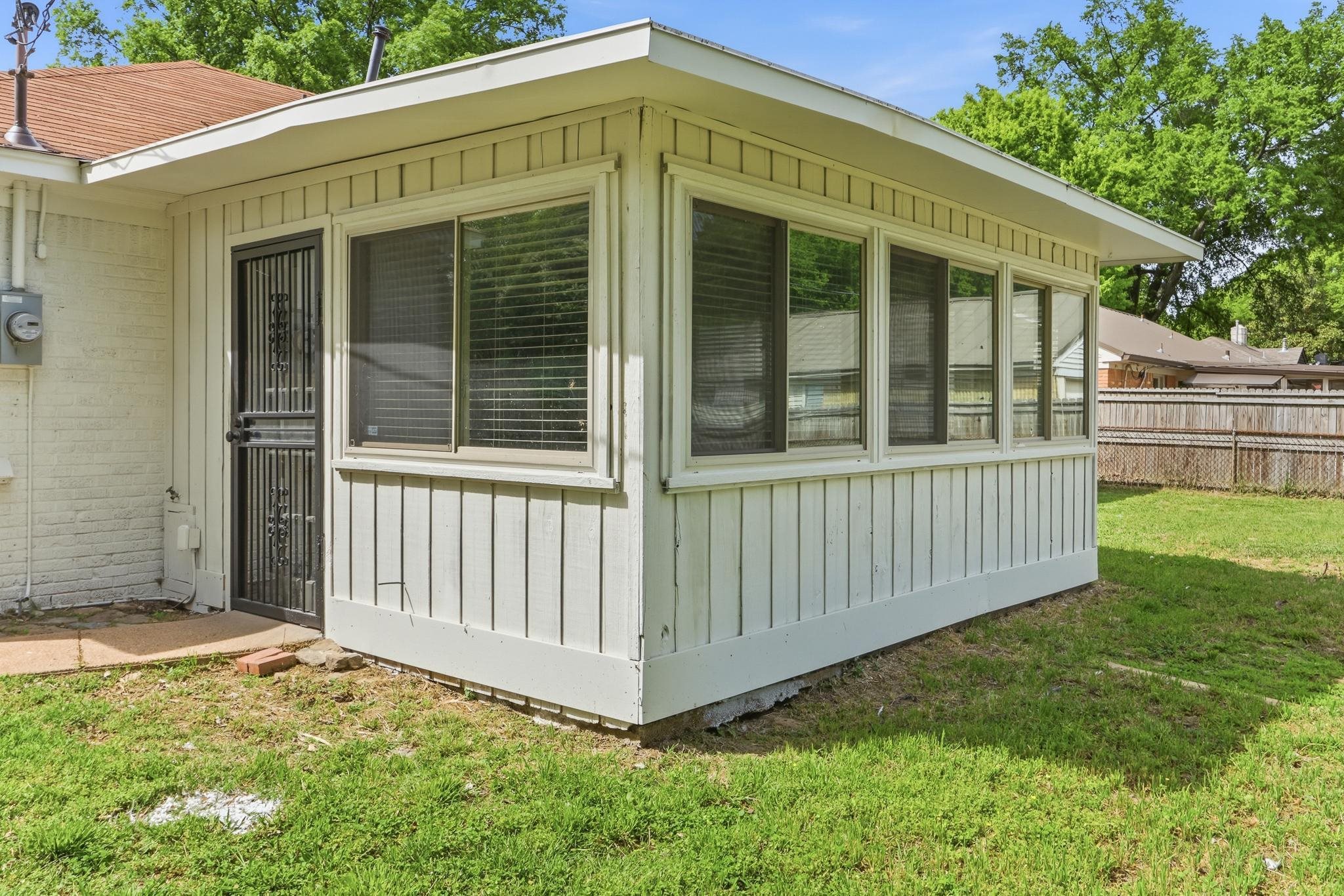 312 Fernway Road Memphis, TN 38117 - Photo 29 of 38 View of side of property with a sunroom, board and batten siding, and brick siding