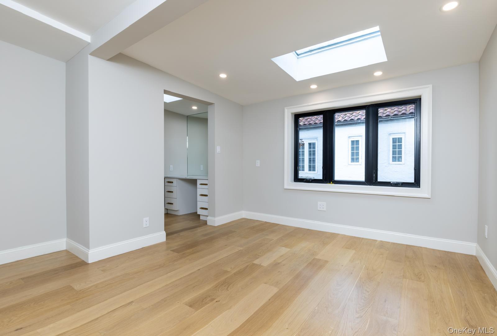 120 Baker Hill Road Great Neck, NY 11023 - Photo 20 of 25 a view of an empty room with a window and wooden floor
