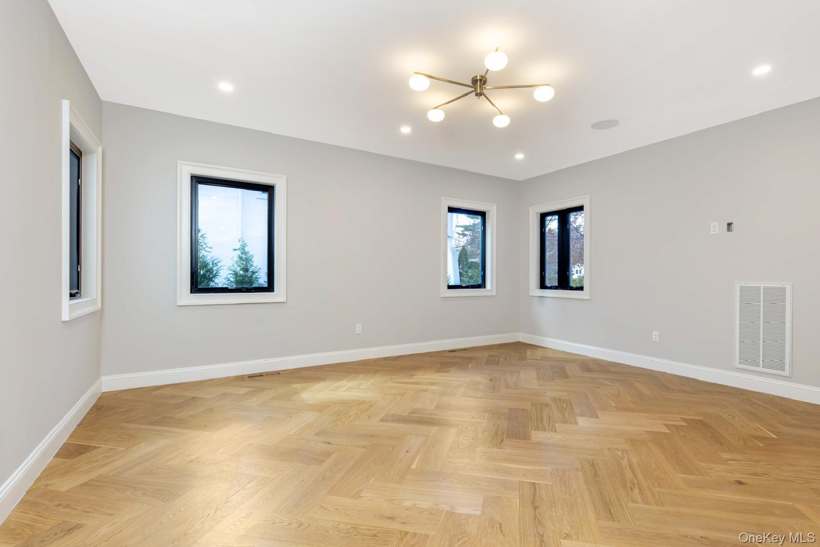 120 Baker Hill Road Great Neck, NY 11023 - Photo 24 of 25 a view of an empty room with window and chandelier fan