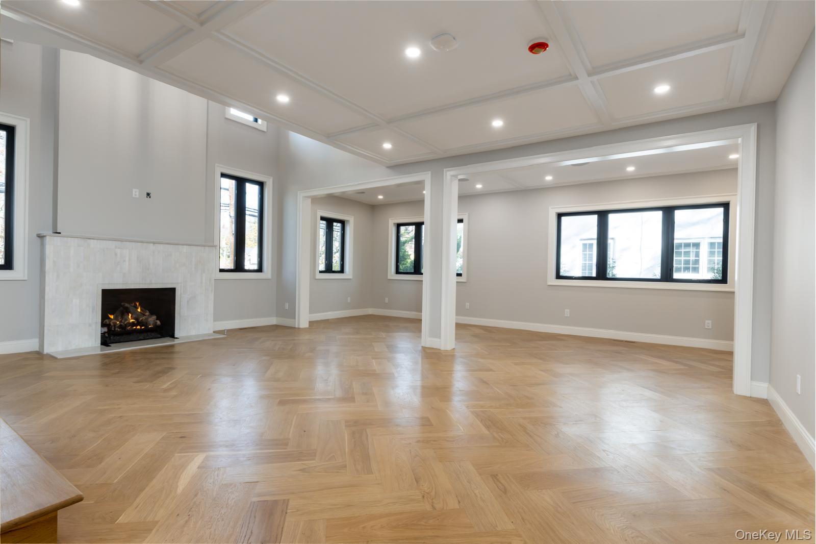 120 Baker Hill Road Great Neck, NY 11023 - Photo 10 of 25 an empty room with wooden floor fireplace and windows