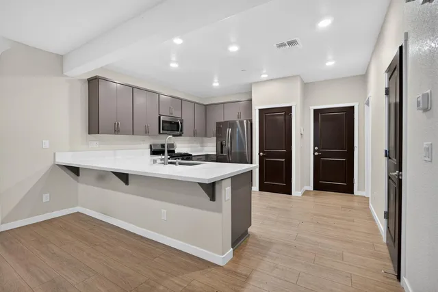 a kitchen with stainless steel appliances granite countertop a refrigerator and a sink