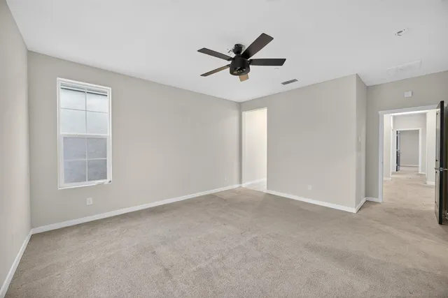 a view of a livingroom with a ceiling fan and window