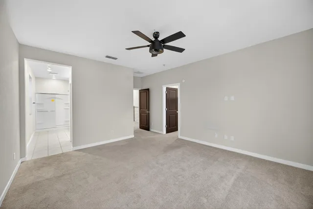 a view of a livingroom with a ceiling fan & window