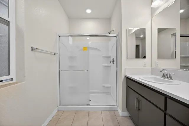 a bathroom with a granite countertop shower sink and mirror