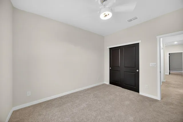 an empty room with closet and windows