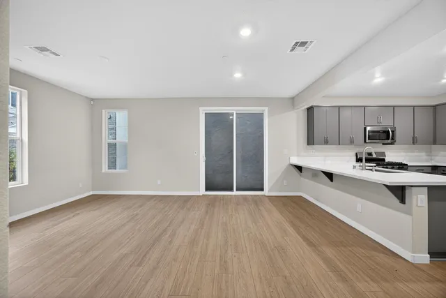 a view of kitchen with wooden floor and electronic appliances