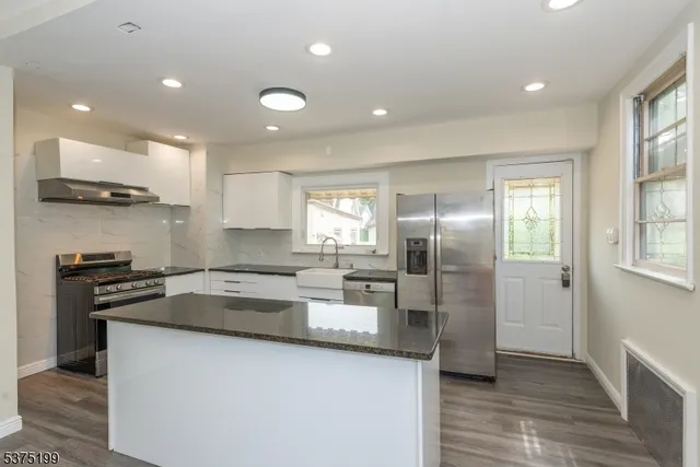 a kitchen with stainless steel appliances granite countertop a sink and a stove