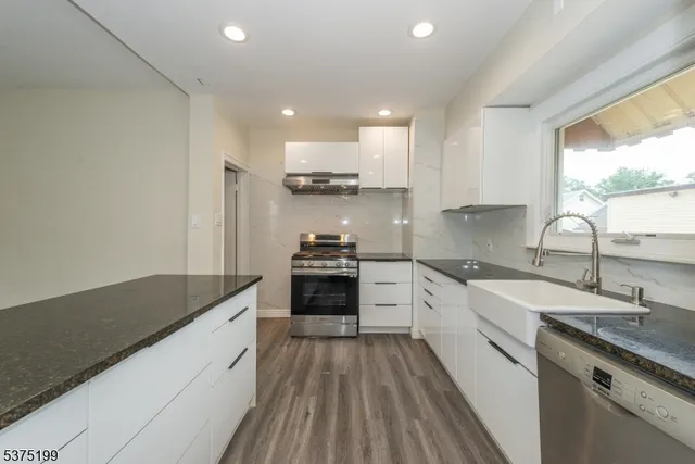 a kitchen with a sink stove top oven and cabinets