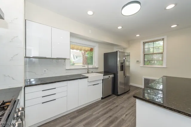 a kitchen with white cabinets and sink