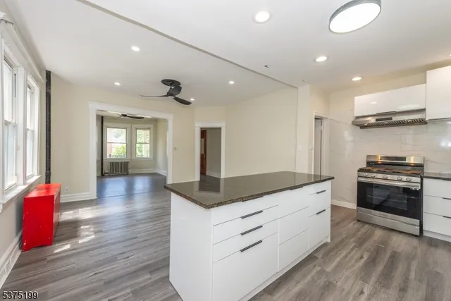 a kitchen with stainless steel appliances granite countertop a stove a sink and a refrigerator
