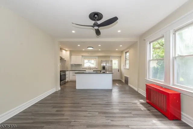 a view of a kitchen with kitchen island stainless steel appliances wooden floor and window