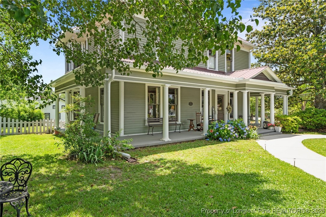 300 High Street Aberdeen, NC 28315 - Photo 2 of 50 a view of a house with a yard and potted plants