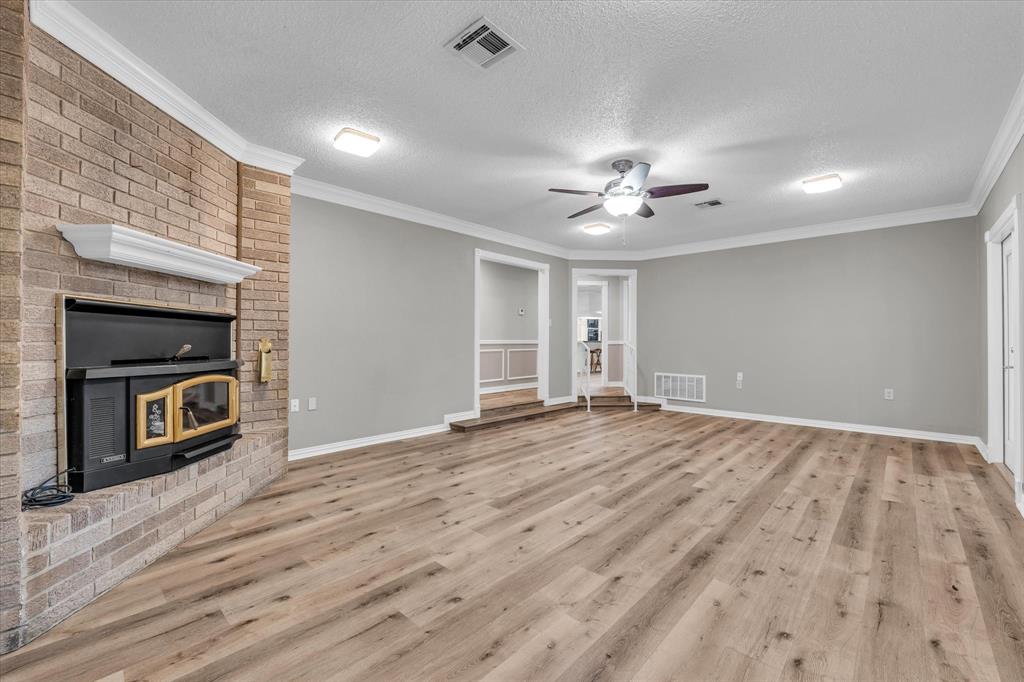 15796 Chapel Road Lorena, TX 76655 - Photo 13 of 28 wooden floor fireplace and natural light in empty room