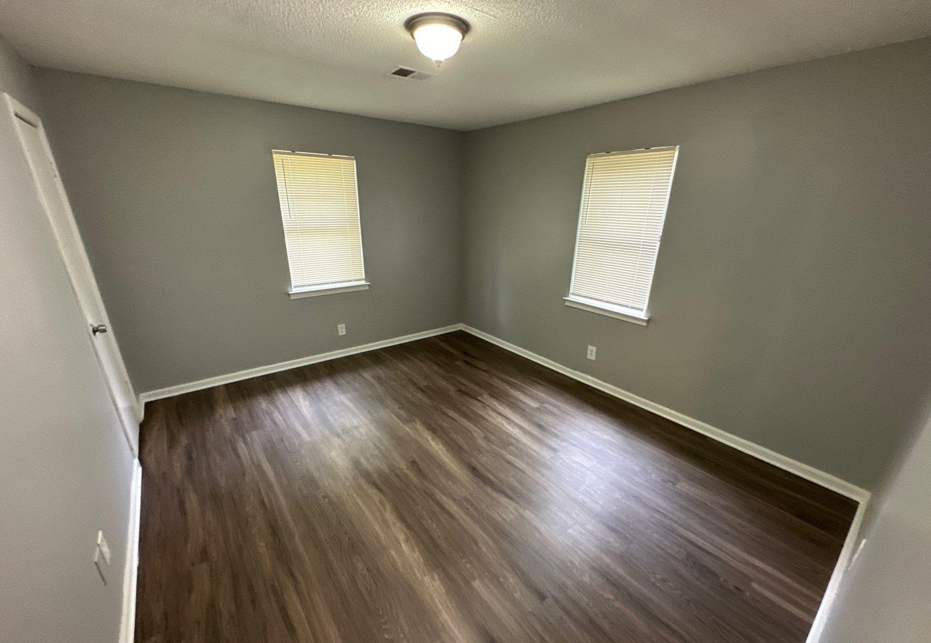 4758 11th Road Memphis, TN 38109 - Photo 6 of 8 an empty room with wooden floor and windows