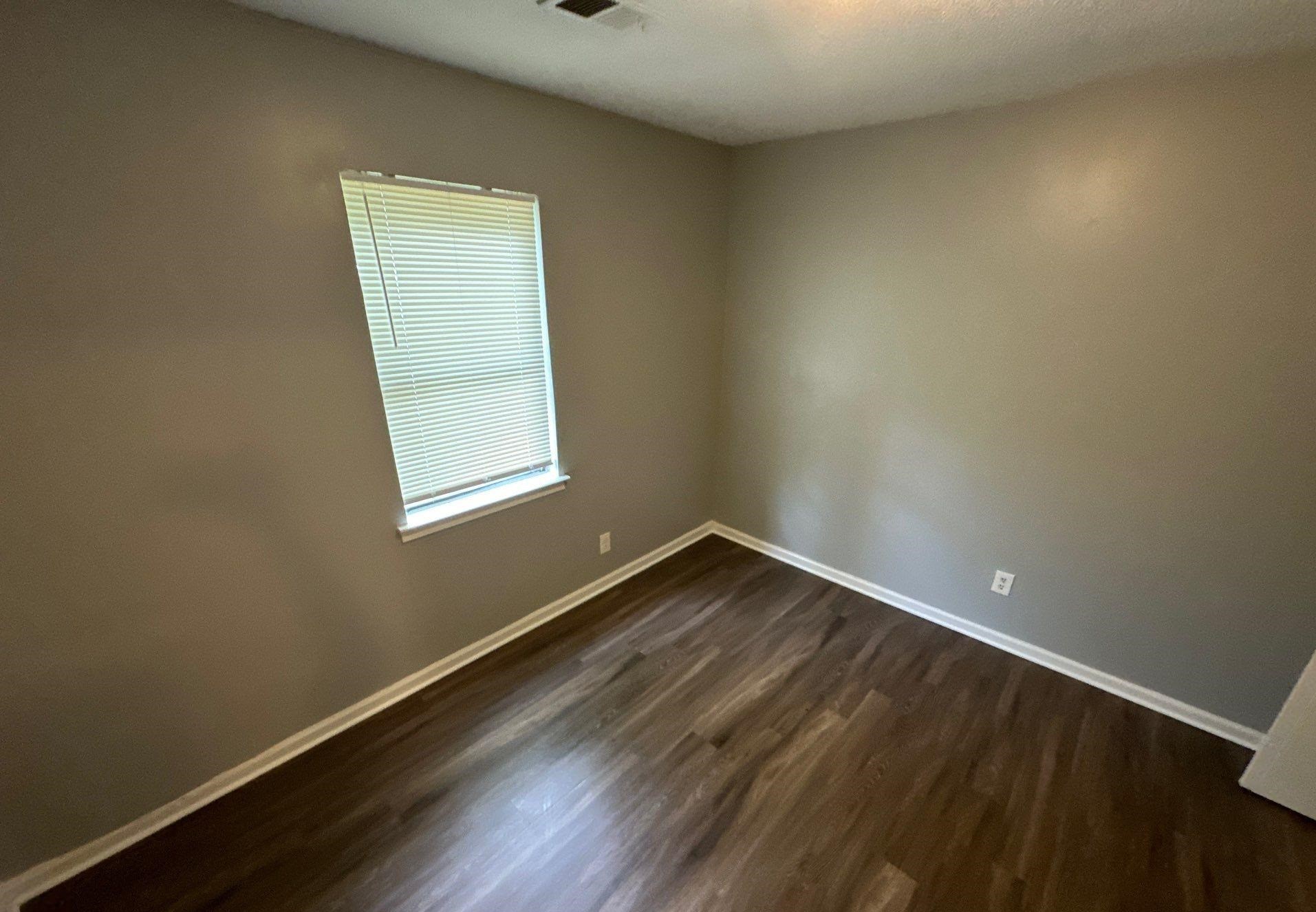 4758 11th Road Memphis, TN 38109 - Photo 7 of 8 an empty room with wooden floor and windows