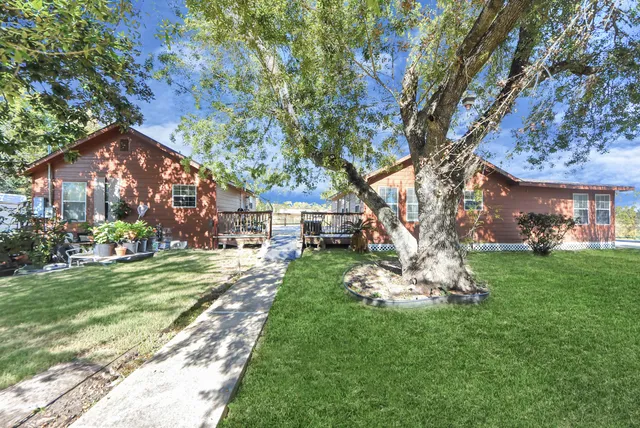 a front view of a house with a yard garden and trees