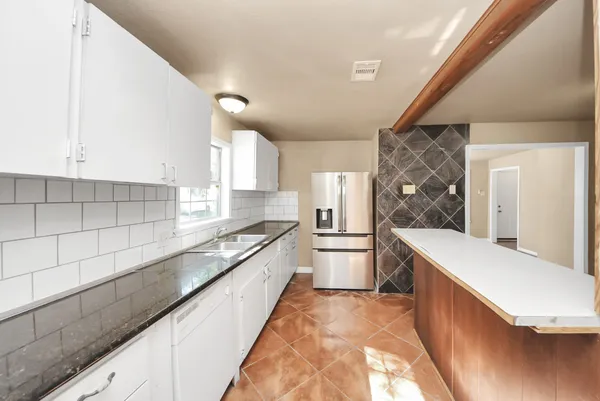 a large white kitchen with a large window