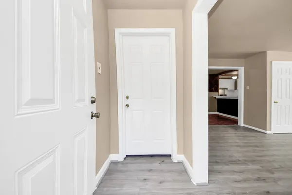a view of a hallway with wooden floor and closet