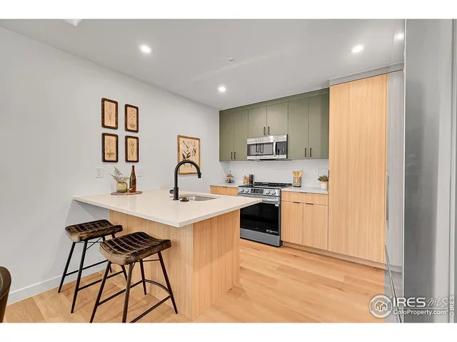 a kitchen with stainless steel appliances kitchen island a sink cabinets and wooden floor