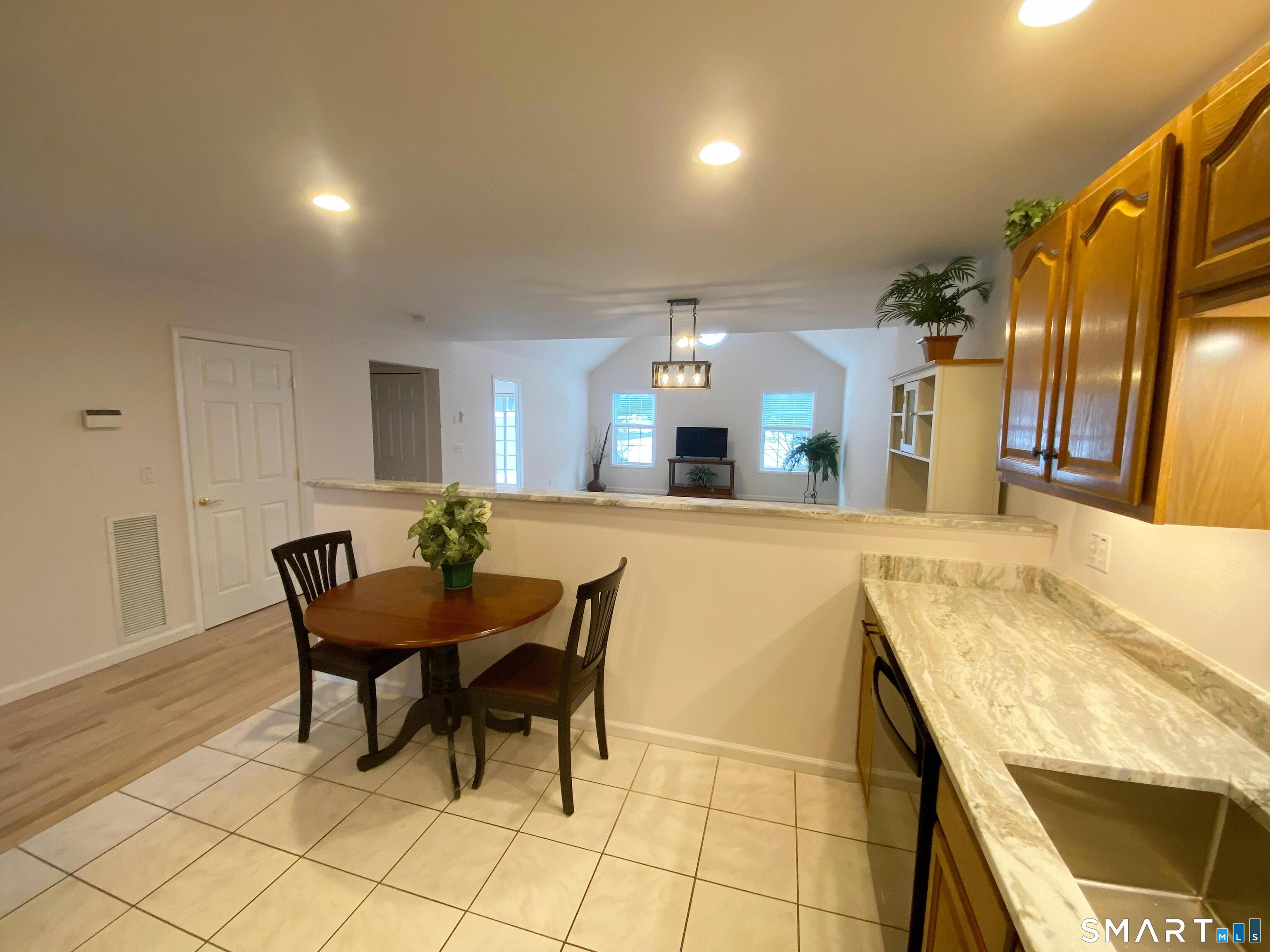 8 St George Place, Unit 8 Newtown, CT 06482 - Photo 8 of 31 a view of a dining room with furniture and a chandelier