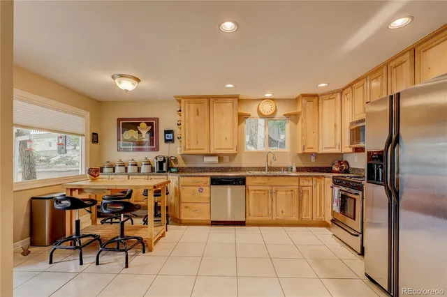 a kitchen with stainless steel appliances granite countertop a refrigerator and a stove top oven