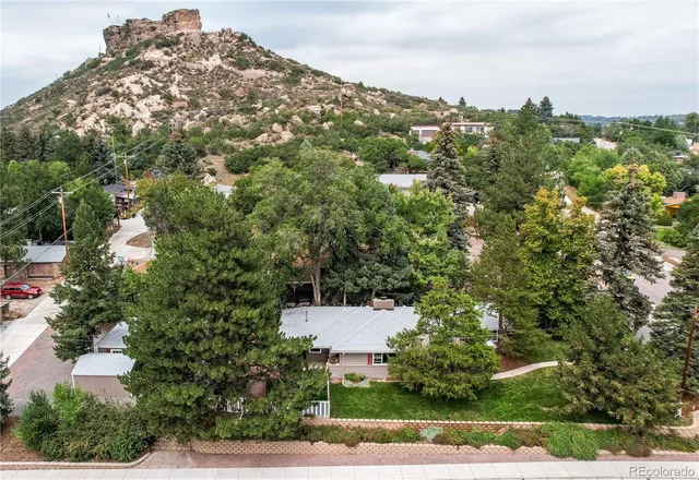 an aerial view of a house with a yard and mountain view in back