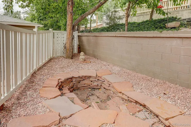 a view of a yard with furniture and wooden fence