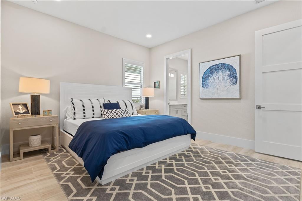 8829 Paradera Court Naples, FL 34112 - Photo 16 of 31 a bedroom with a large bed and a painting on the wall