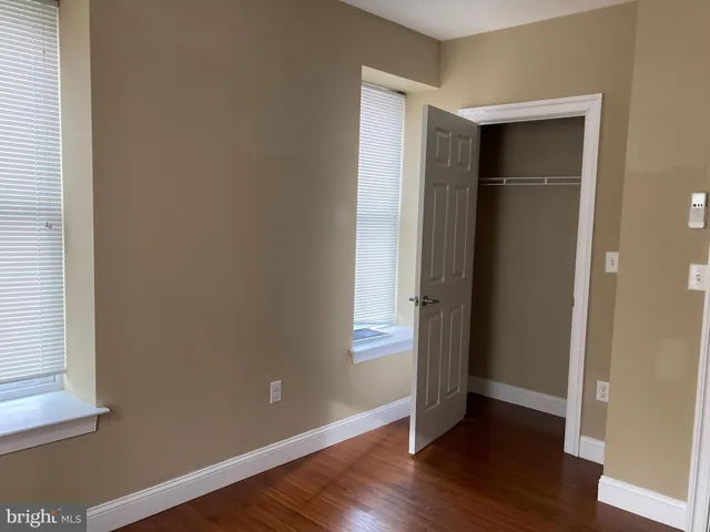 an empty room with wooden floor and a window