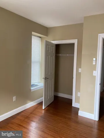an empty room with wooden floor and closet