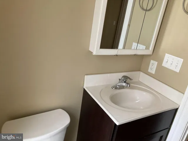 a bathroom with a sink a toilet and mirror