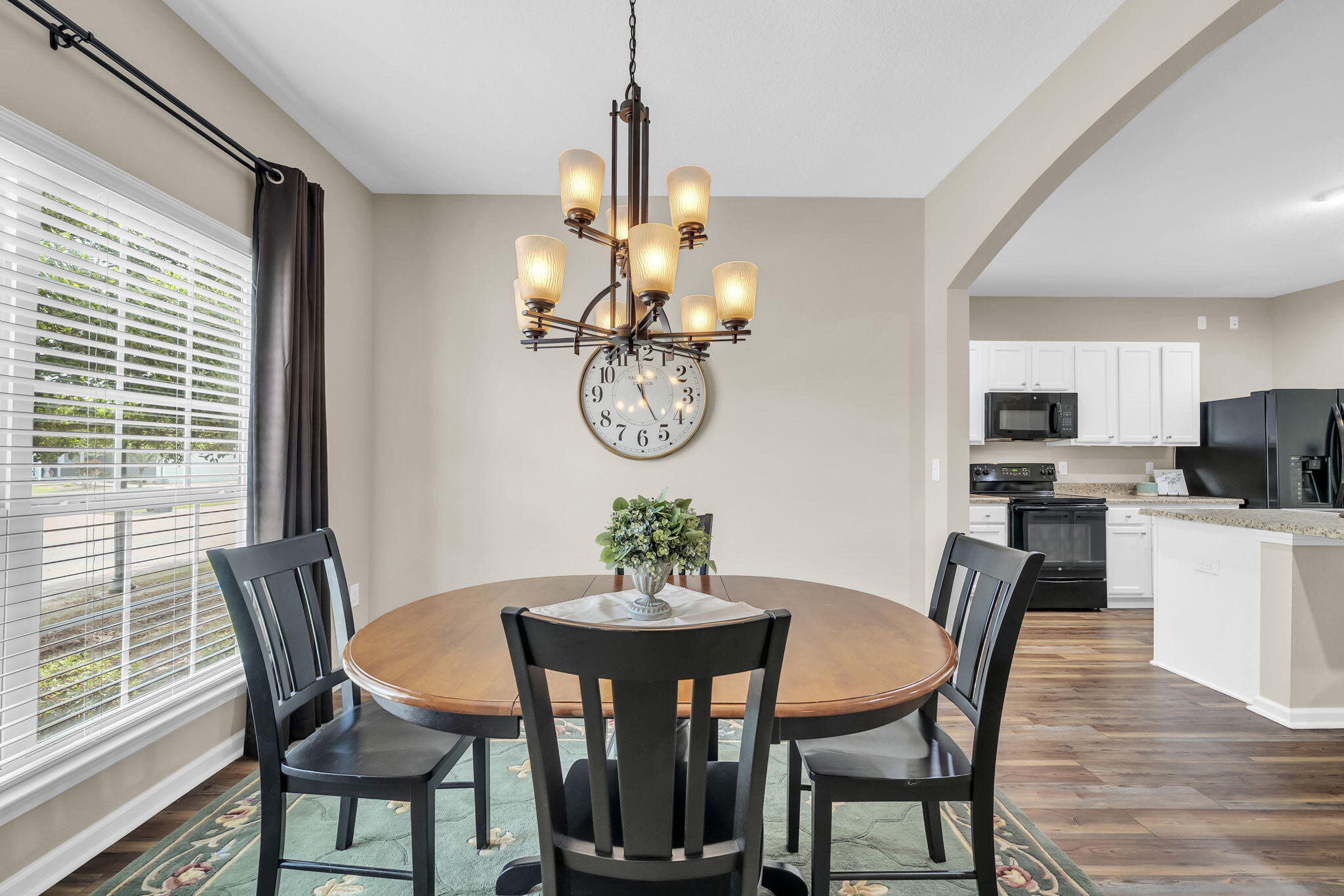 115 Lilly Bell Lane Freeport, FL 32439 - Photo 11 of 47 a dining room with wooden floor a chandelier a wooden table and chairs