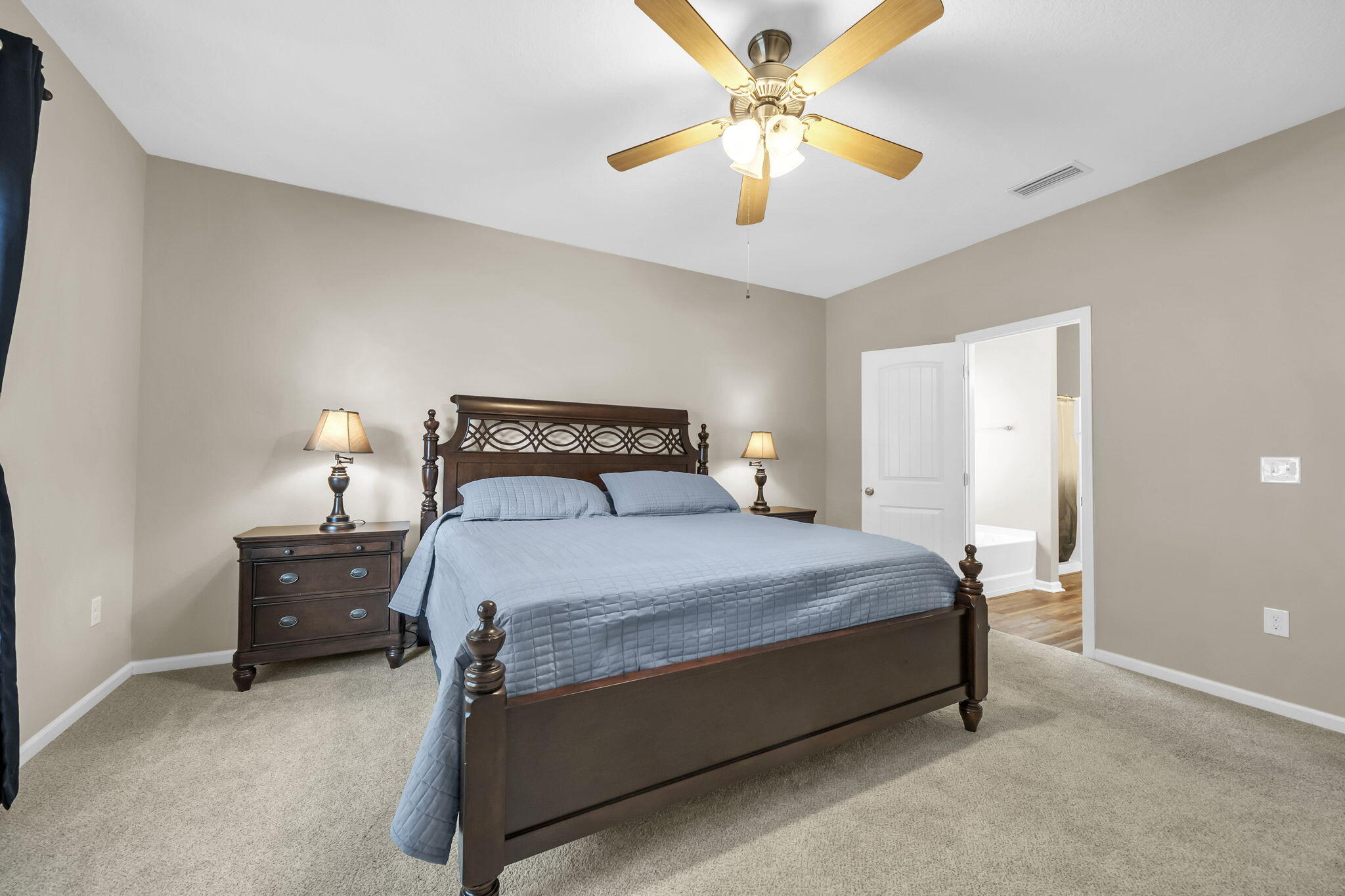 115 Lilly Bell Lane Freeport, FL 32439 - Photo 31 of 47 a bedroom with a bed and a chandelier